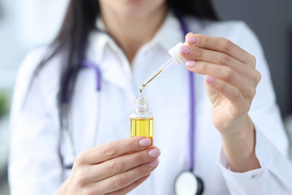 woman doctor holding essential oil bottle